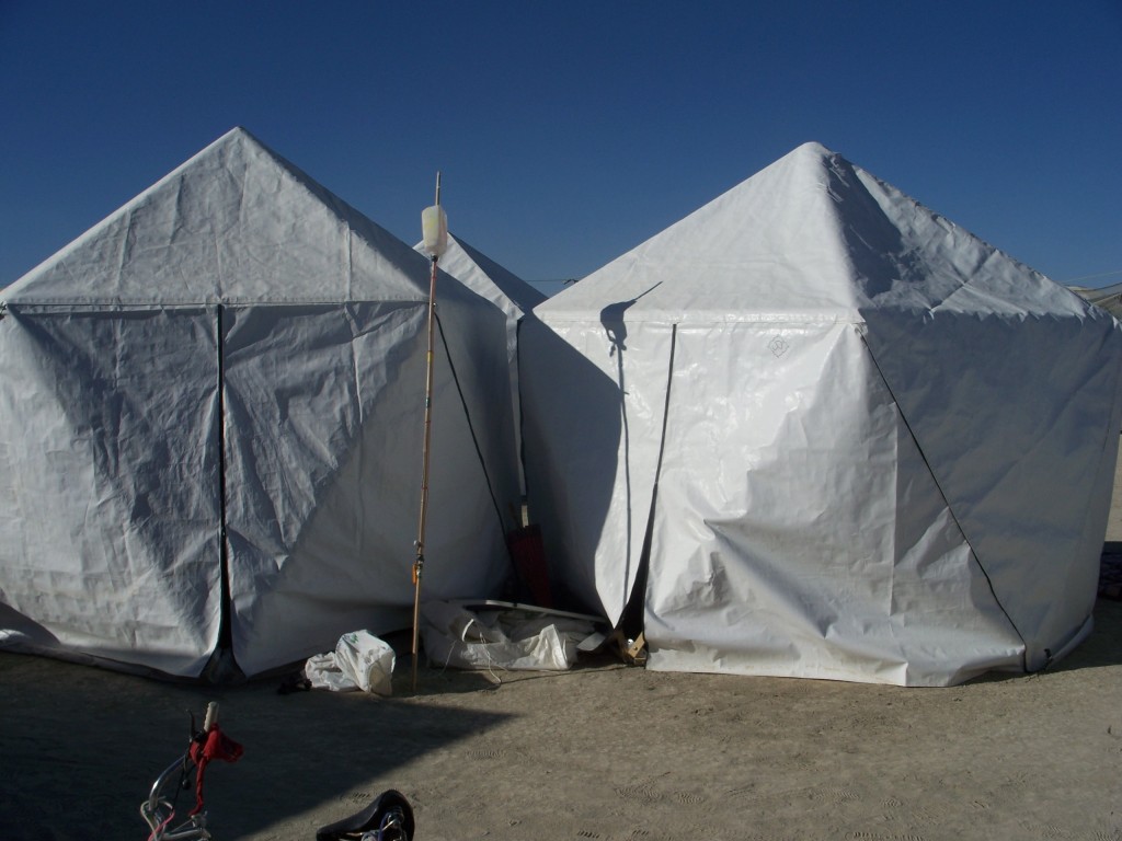 Two white Starpod geodesic tents pitched side by side on the playa